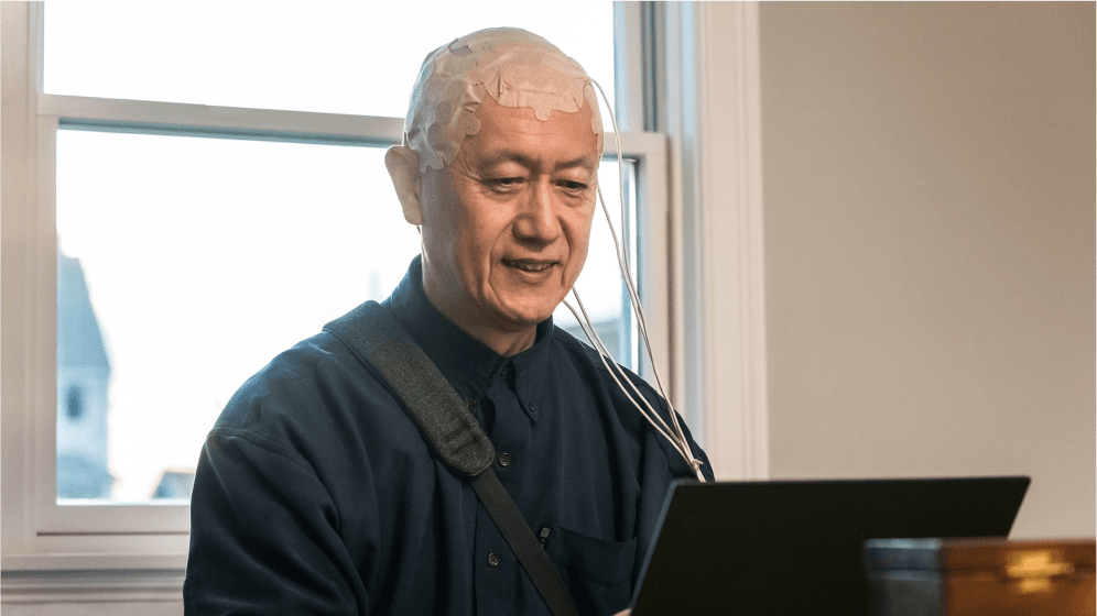 Smiling healthcare professional using a tablet with FAQ icons and medical symbols overlay